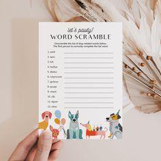 a person holding up a word scramble with animals and balloons on it, next to feathers