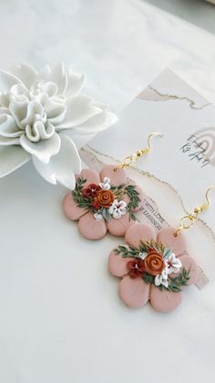 pink flower earrings with white and red flowers on them