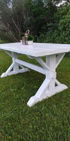 a white table sitting on top of a lush green field