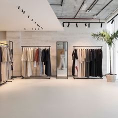 an empty clothing store with clothes on racks