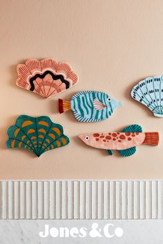 five colorful fish are hanging on the wall