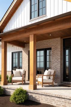 a porch with two chairs and an awning over the front entrance to a house