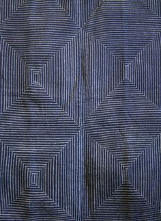 a blue and white fabric with an interesting design on the front, it is very dark