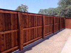 a wooden fence is shown with gravel in the foreground