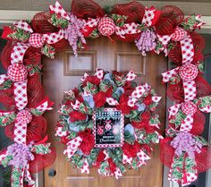 a red and white wreath on a front door