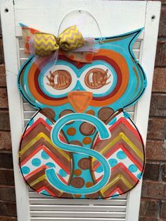 an owl door hanger with a bow on it