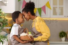 a mother and son are sitting on the kitchen counter, one is holding a basket