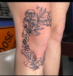 a woman's leg with flowers and mushrooms on it