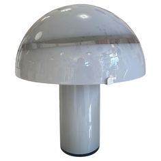 a white table lamp sitting on top of a metal base