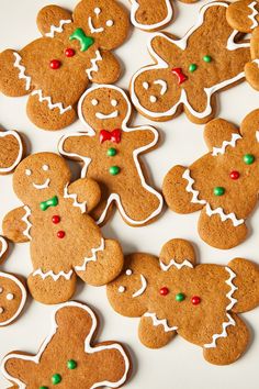 some very pretty decorated ginger cookies on a table with green and red candies around them