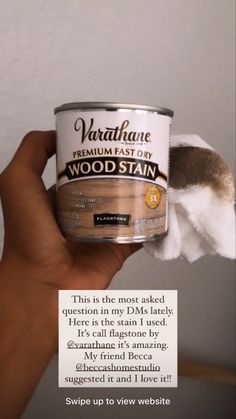 someone is holding up a can of wood stain