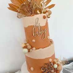 a three tiered cake decorated with gold and white decorations on it's side