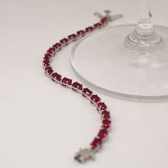 "A gorgeous 7.25\" sterling silver tennis bracelet featuring 21 bright 6 x 4 mm prong-set Ruby gemstones. A thoughtful birthday gift or timeless accessory that pairs brilliantly with any fashion. Explore All Of Our Timeless Jewelry: https://www.etsy.com/shop/JOHNWESHDESIGNS All JohnWeshDesigns jewelry is handcrafted and designed to meet the lifestyle needs of fashionable clientele. Whether formal or casual, statement or minimalistic, we can help you accessorize your ensemble with affordable tren Ruby Tennis Bracelet, Ruby Bracelet, Tennis Bracelet Diamond, Ruby Gemstone, Timeless Accessories, Jewelry Lookbook, Pink Bracelet, Topaz Gemstone, Trendy Jewelry