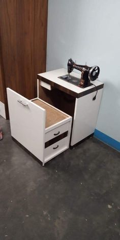 a sewing machine sitting on top of a white cabinet