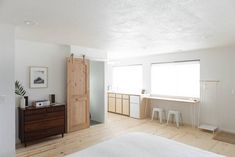 a bedroom with white walls and wooden floors