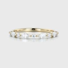 a yellow gold band with five pear shaped diamonds