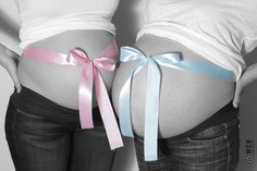 two pregnant women with their butts tied up and wearing matching bows, standing next to each other