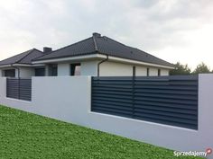 a house with a fence in front of it and grass on the ground next to it