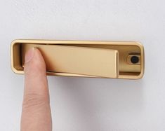 a person is pressing the button on a door handle with their thumb and index finger