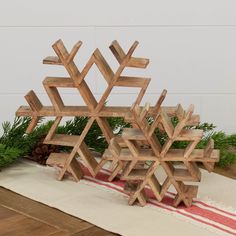 a wooden snowflake sitting on top of a table next to pine cones and greenery