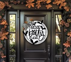 the front door is decorated with fall leaves and pumpkins