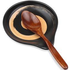 a wooden spoon sitting on top of a black plate