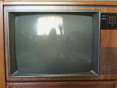 an old television with the hand up in front of it