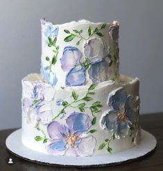 two tiered cake decorated with blue and purple flowers