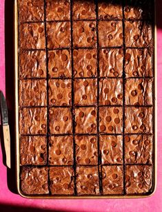 a pan filled with brownies on top of a pink table