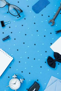 various office supplies laid out on a blue surface