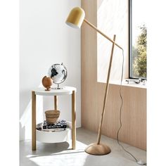 a lamp that is on top of a table next to a book shelf and window