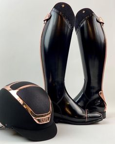 a pair of black boots with gold trims and a hat on the floor next to it