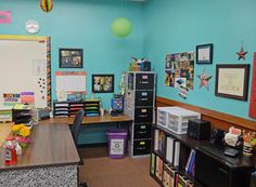 a classroom with blue walls and pictures on the wall