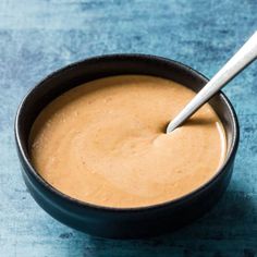 a bowl filled with peanut butter on top of a blue table