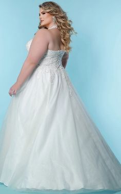 a woman in a wedding dress posing for the camera with her hands on her hips