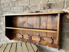 a wooden coat rack with hooks on it