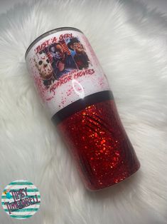 a red glitter tumbler with an image of horror movies on it