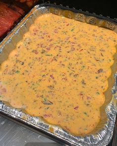 an uncooked casserole dish with meat in the background