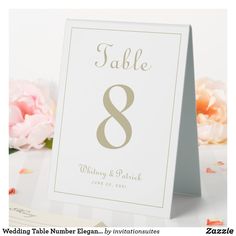 a table number card with the number eight on it and pink flowers in the background