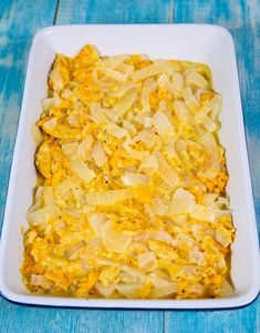 a casserole dish with noodles and cheese in it on a blue wooden table