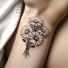 a black and white tattoo with flowers on the side of a woman's arm