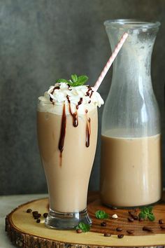 two glasses filled with milkshakes sitting on top of a table