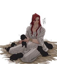 a woman with red hair sitting on the ground holding a small black cat in her lap