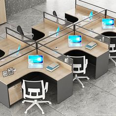 an office cubicle with four desks and three computers on each workstation area