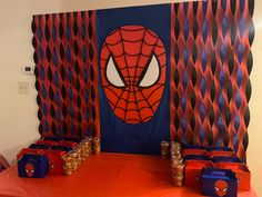 a spiderman themed birthday party with orange and blue candy boxes on an orange table