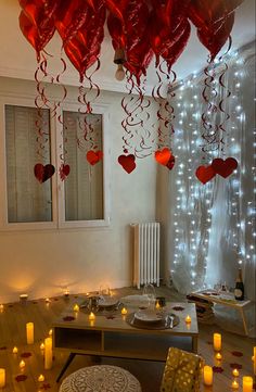 valentine's day decorations with candles and hearts hanging from the ceiling