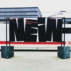 two black and white signs sitting on top of cement blocks in front of a building