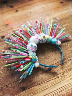 a bunch of different colored toothbrushes on a wooden table with other items around it