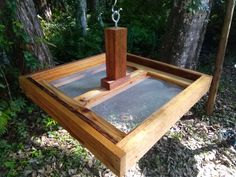 a wooden table with a glass top in the woods