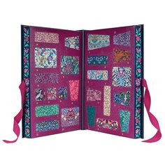 an open book with many different designs on the pages and ribbons hanging from each side